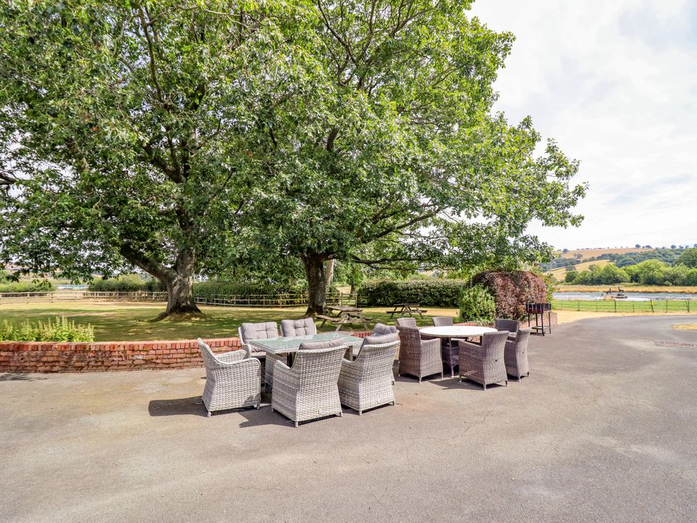 An outdoor seating area with a table and chairs at Bodaioch Hall Trefeglwys near Caersws