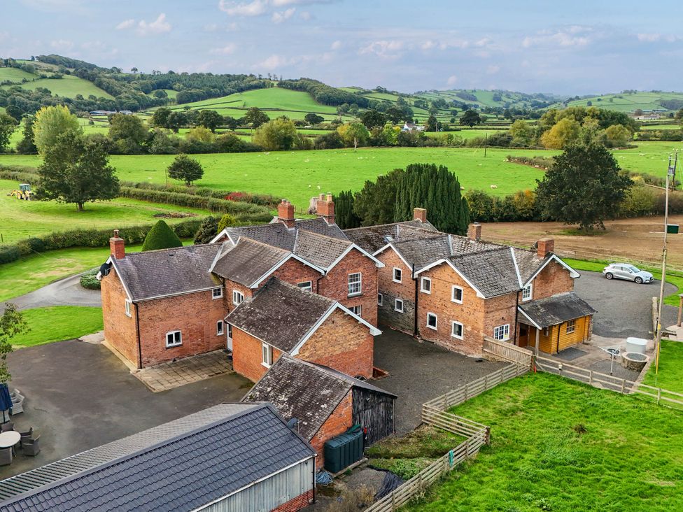 A view of multiple buildings and fields at Bodaioch Hall in Trefeglwys near Caersws