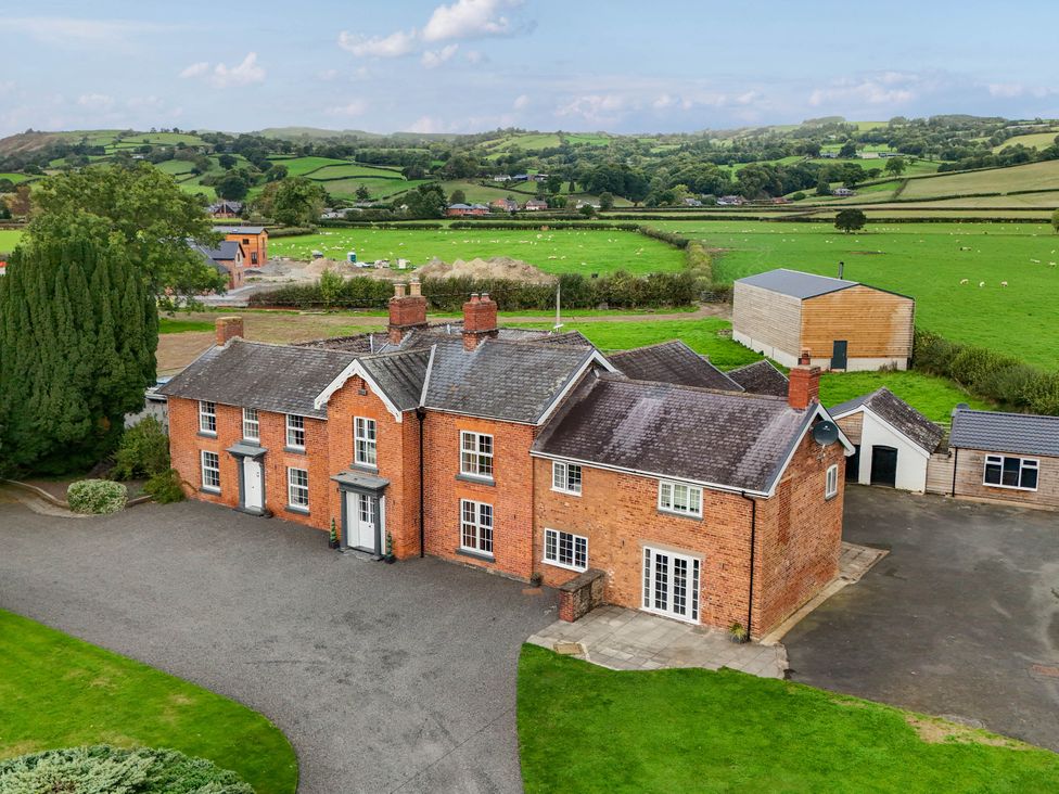 A brick house with surrounding fields at Bodaioch Hall in Trefeglwys near Caersws