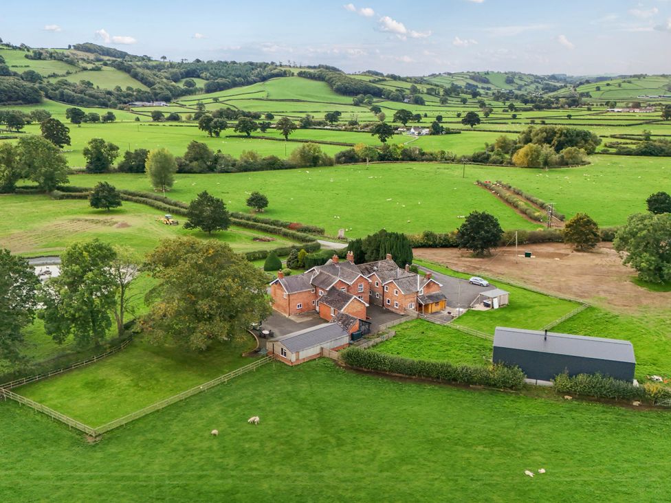 An aerial view of a farmhouse and fields at Bodaioch Hall Trefeglwys near Caersws