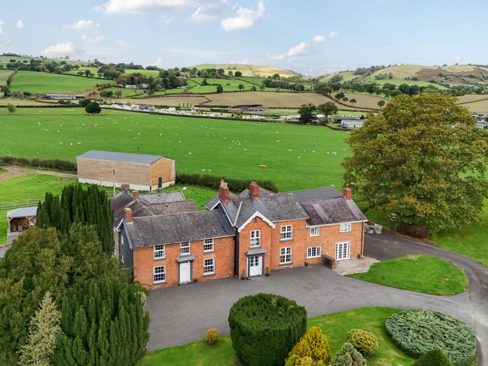 An exterior view of a house with fields and trees at Bodaioch Hall Trefeglwys near Caersws