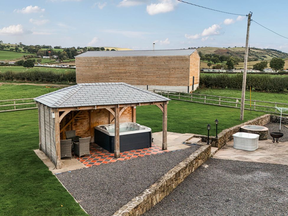 A garden with a hot tub and gazebo at Bodaioch Cottage Trefeglwys near Caersws