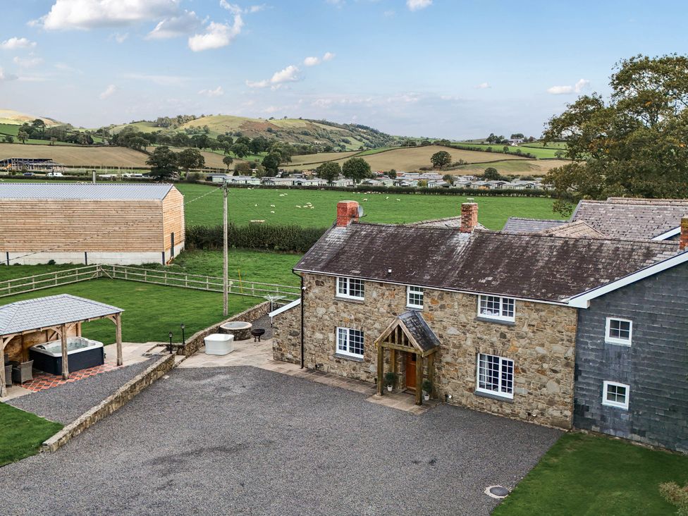 A house with a hot tub and outdoor seating at Bodaioch Cottage Trefeglwys near Caersws