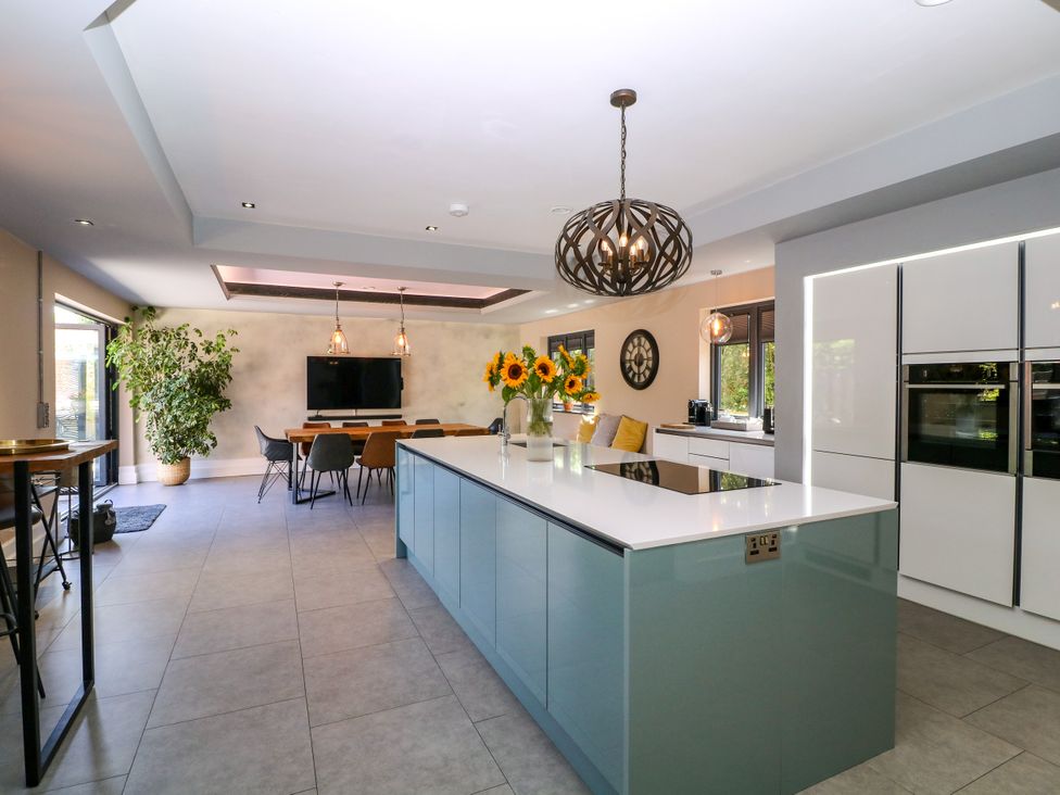A kitchen with a large island and dining area at Thornbury in Barnard's Green, Malvern