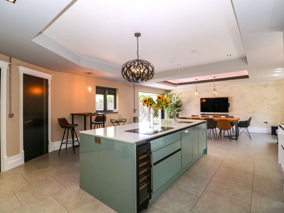 A kitchen with an island and dining area at Thornbury, Barnard's Green, Malvern