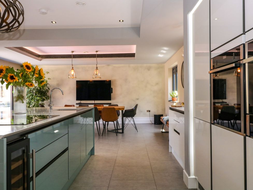 A kitchen with a dining area and sunflowers at Thornbury in Barnard's Green, Malvern