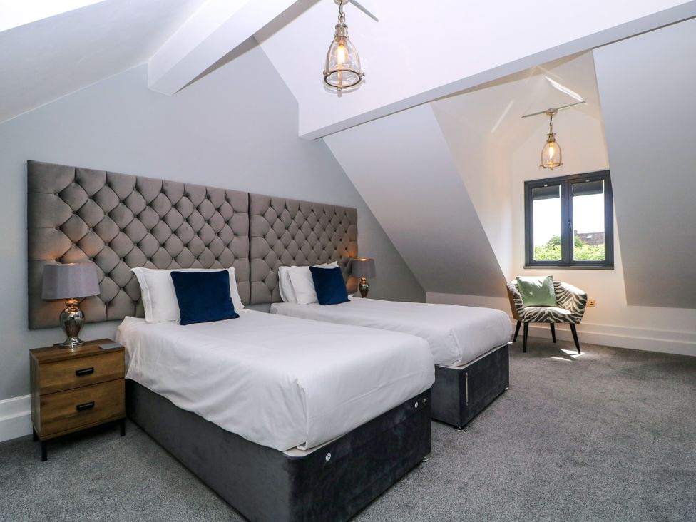 A bedroom with two single beds and a chair at Thornbury in Barnard's Green, Malvern