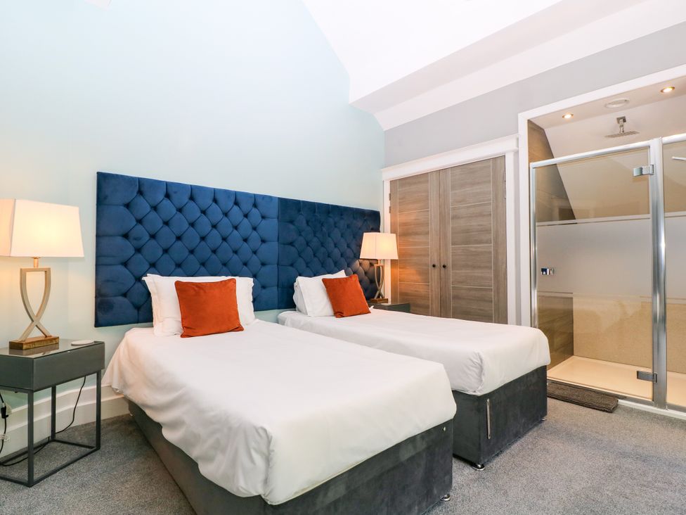 A bedroom with twin beds and an ensuite shower at Thornbury in Barnard's Green, Malvern