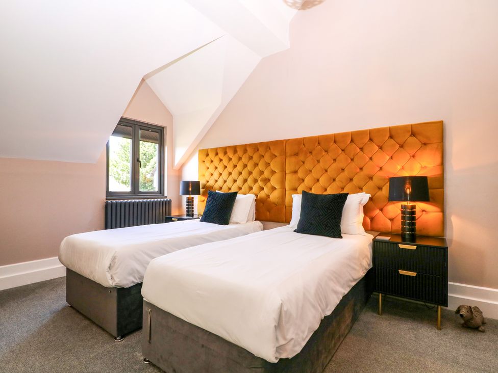 A bedroom with two beds and a window at Thornbury, Barnard's Green, Malvern