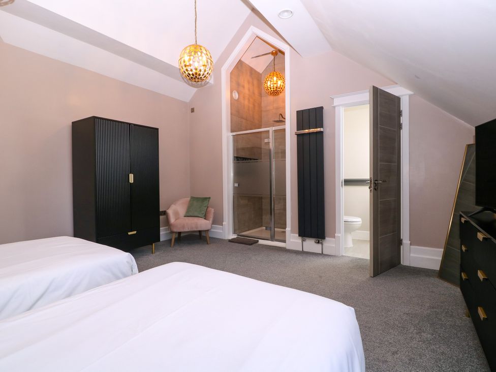 A bedroom with two beds and an ensuite shower at Thornbury in Barnard's Green, Malvern