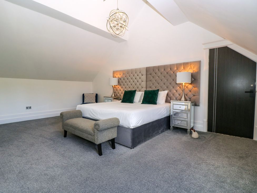 A bedroom with a bed and side tables at Thornbury, Barnard's Green, Malvern