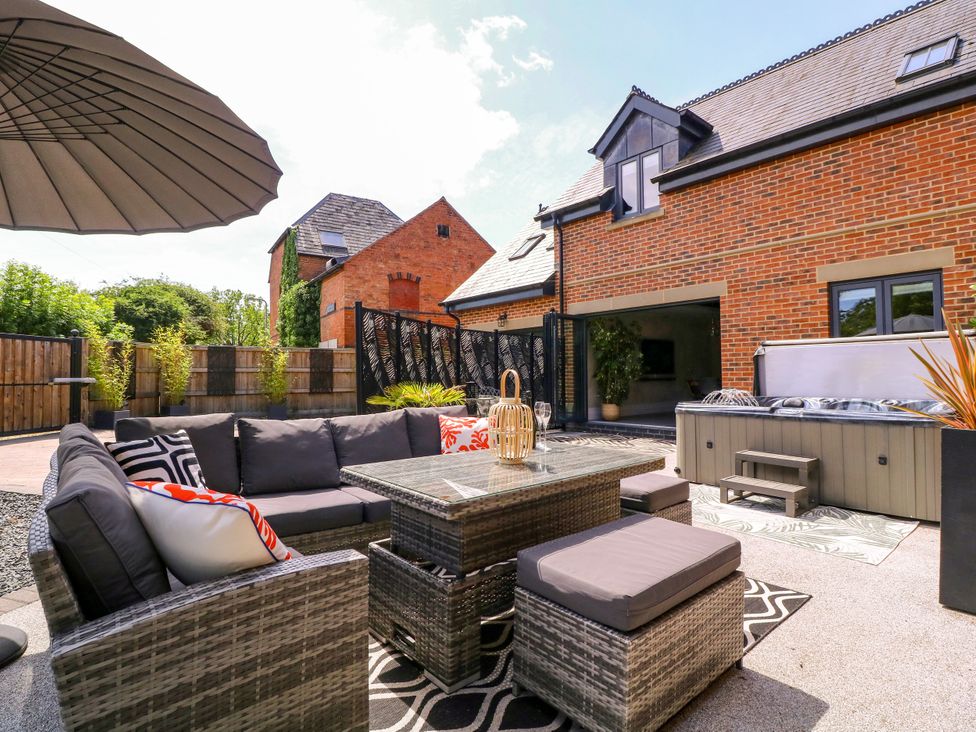 A garden with a seating area and hot tub at Thornbury in Barnard's Green, Malvern