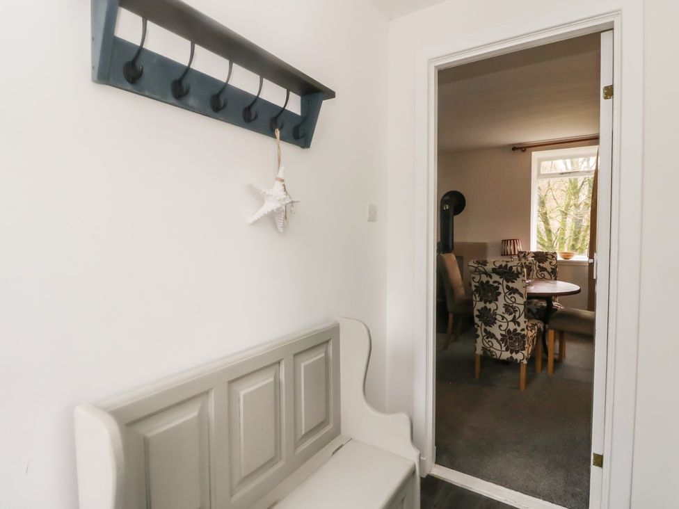 A hallway with a bench and coat hooks at Willow near Inveraray