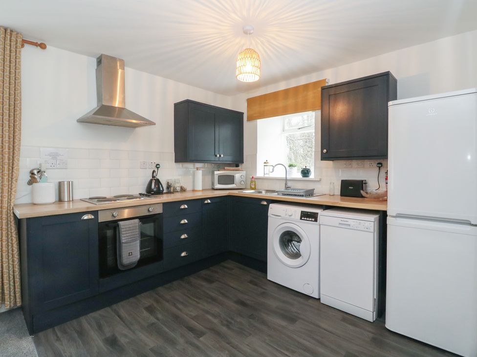 A kitchen with appliances including a fridge, oven, and washing machine at Willow, Killean Farmhouse Cottages near Inveraray