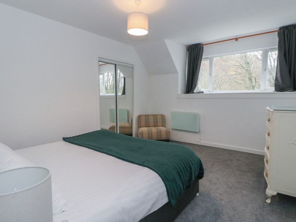 A bedroom with a bed and mirror at Willow Killean Farmhouse Cottages near Inveraray