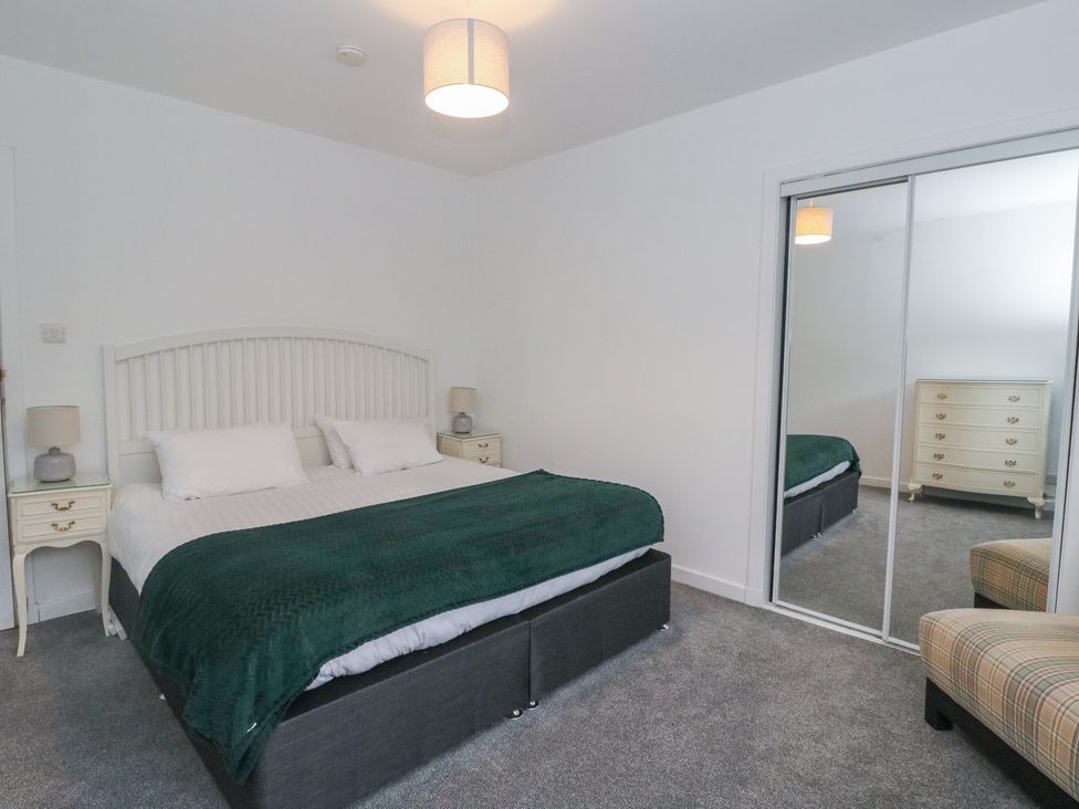 A bedroom with a bed and dresser at Willow in Killean Farmhouse Cottages near Inveraray