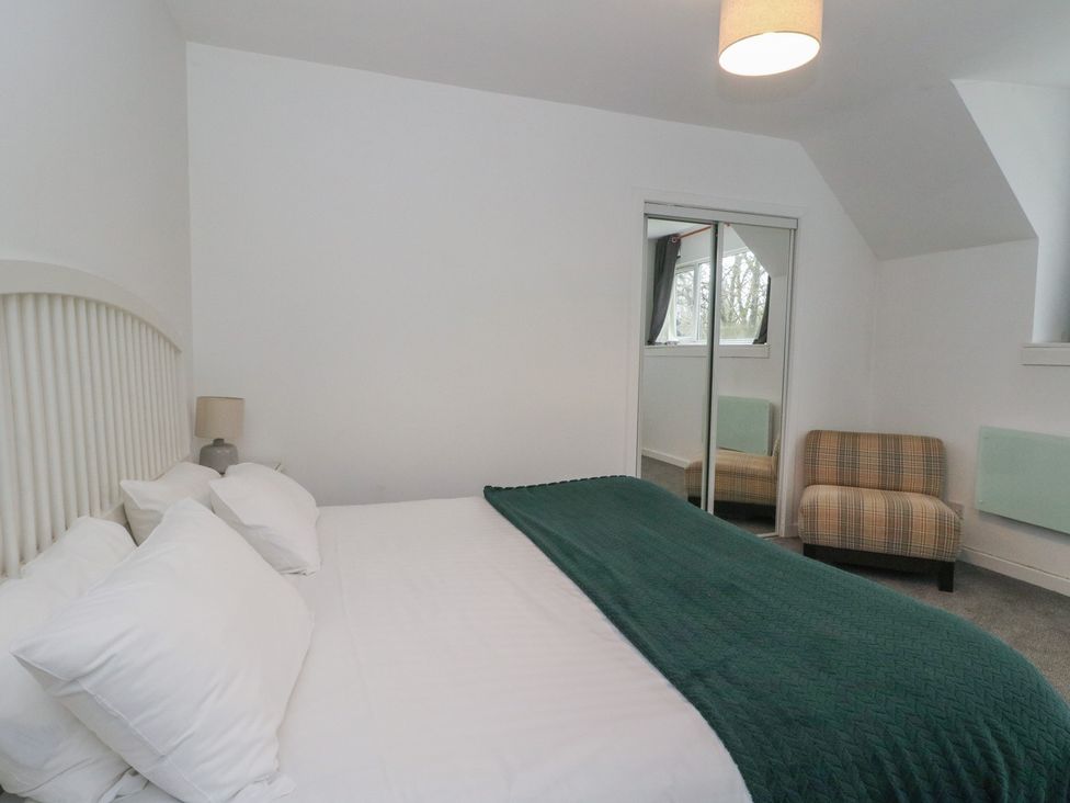 A bedroom with a bed and a chair at Willow, Killean Farmhouse Cottages near Inveraray