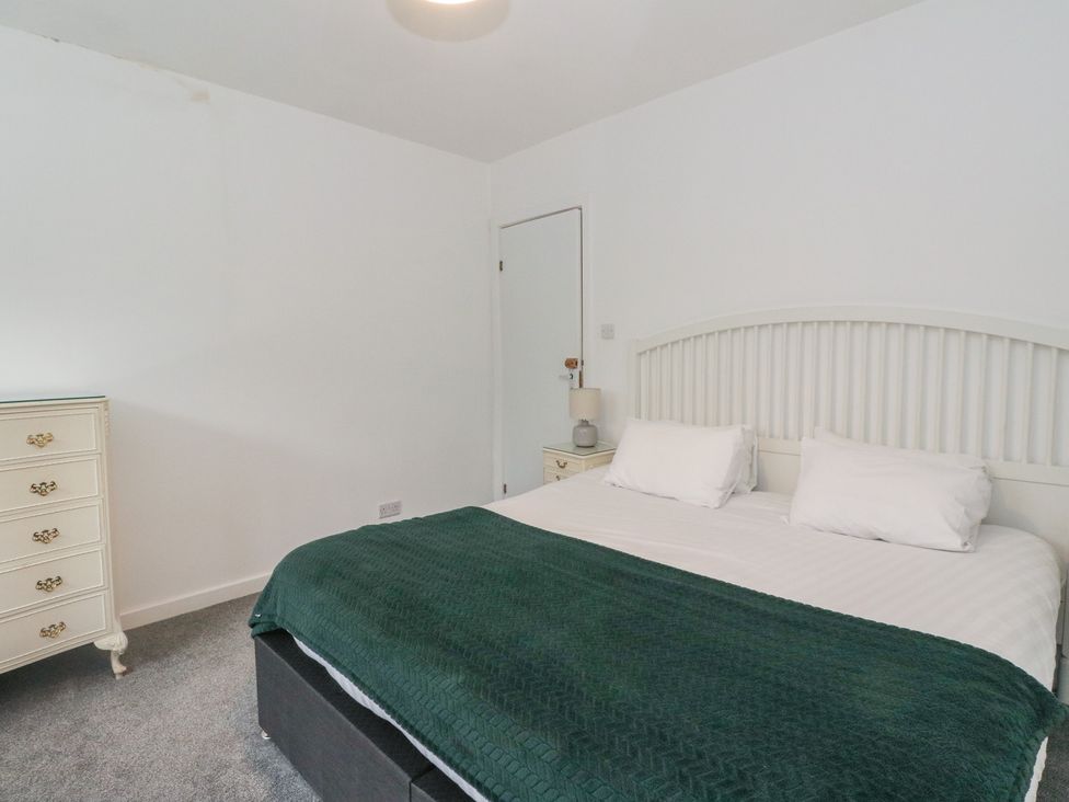 A bedroom with a bed and dresser at Willow near Killean Farmhouse Cottages Inveraray