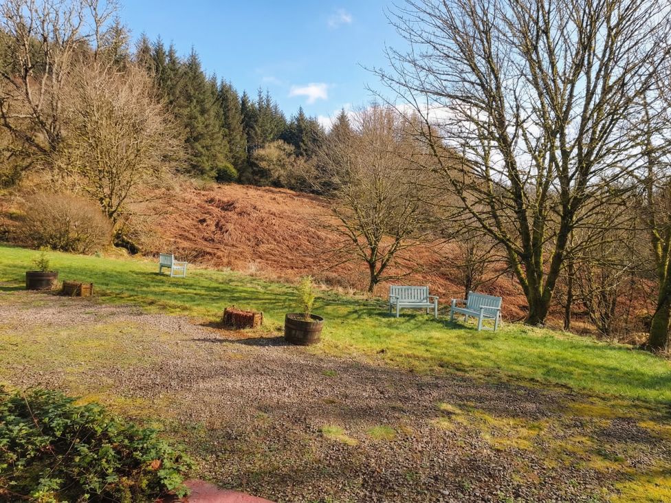 An outdoor area with benches and trees at Willow near Killean Farmhouse Cottages near Inveraray