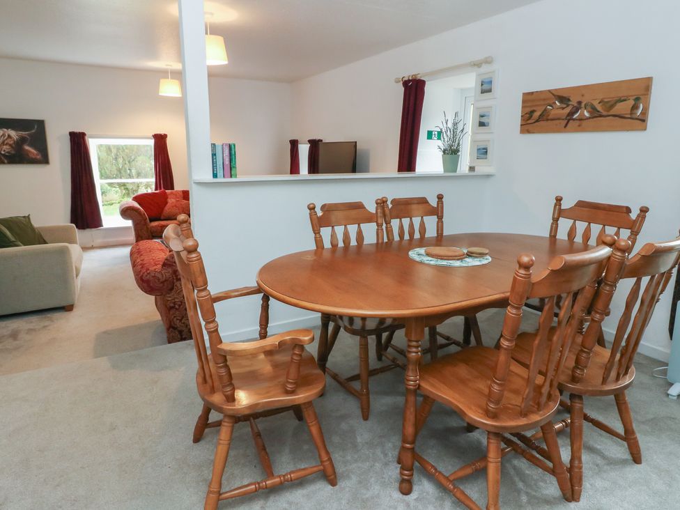 A dining room with a wooden table and chairs at Hawthorn Killean Farmhouse Cottages near Inveraray