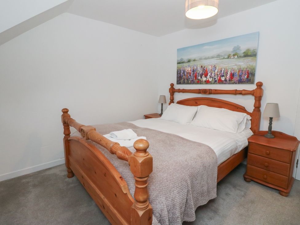 A bedroom with a wooden bed and nightstands at Hawthorn Killean Farmhouse Cottages near Inveraray
