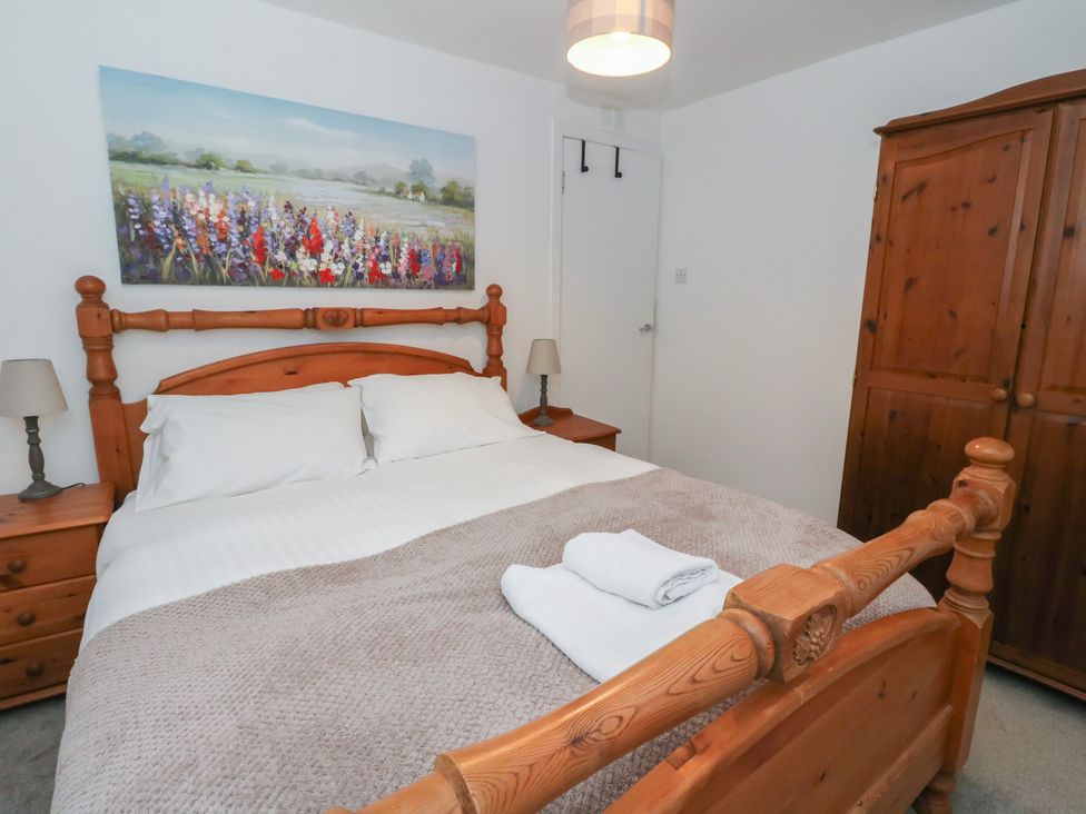 A bedroom with a bed and wooden furniture at Hawthorn near Killean Farmhouse Cottages Inveraray