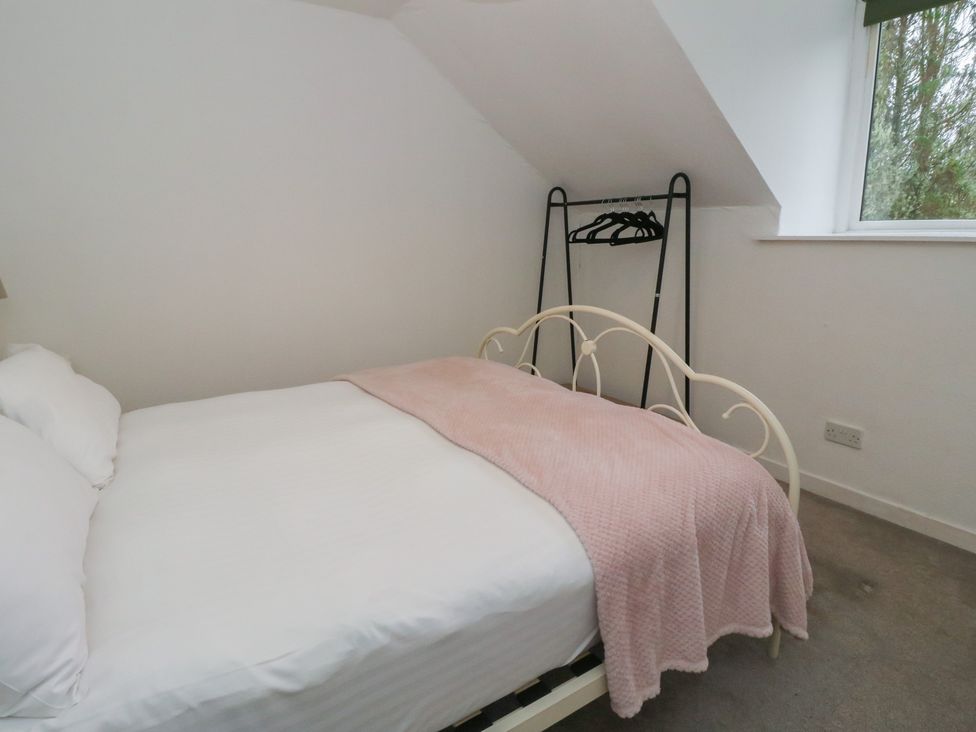 A bedroom with a bed and clothes rack at Hawthorn near Killean Farmhouse Cottages near Inveraray