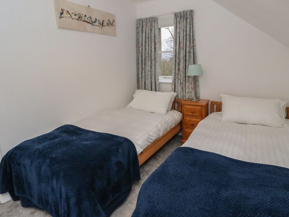 A bedroom with two single beds and a nightstand at Hawthorn, Killean Farmhouse Cottages near Inveraray