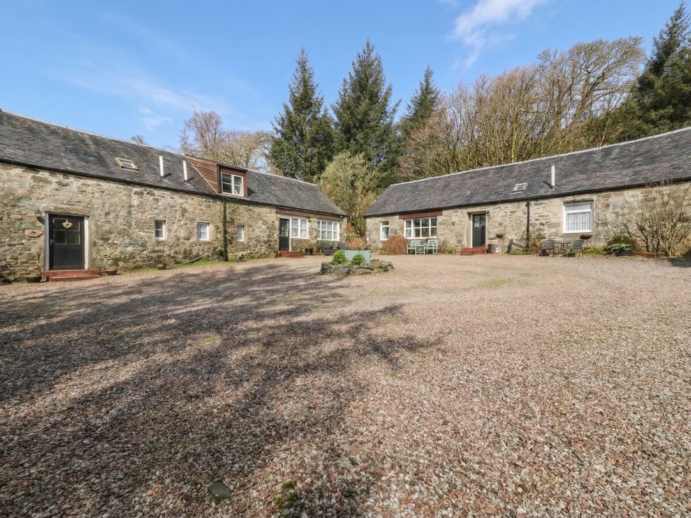 A courtyard with cottages and garden furniture at Hawthorn, Killean Farmhouse Cottages near Inveraray