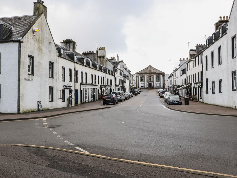 A street view with buildings and parked cars at Hawthorn Killean Farmhouse Cottages near Inveraray