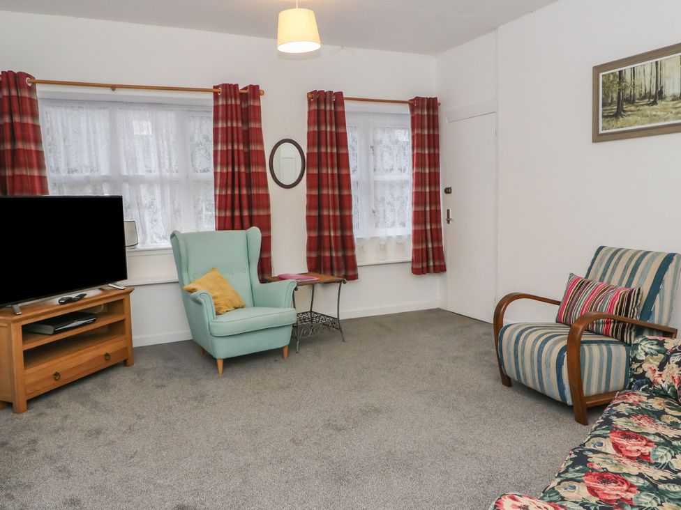 A living room with a television and two armchairs at Holly Cottage near Killean Farmhouse Cottages