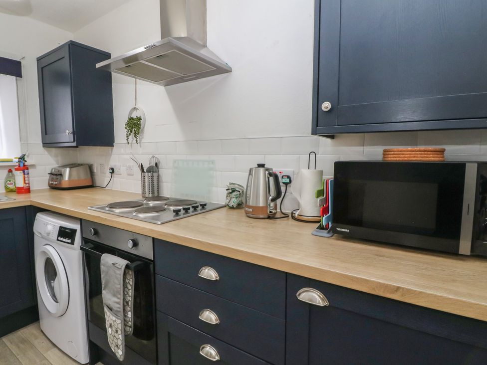 A kitchen with stove and washing machine at Holly Cottage near Killean Farmhouse Cottages