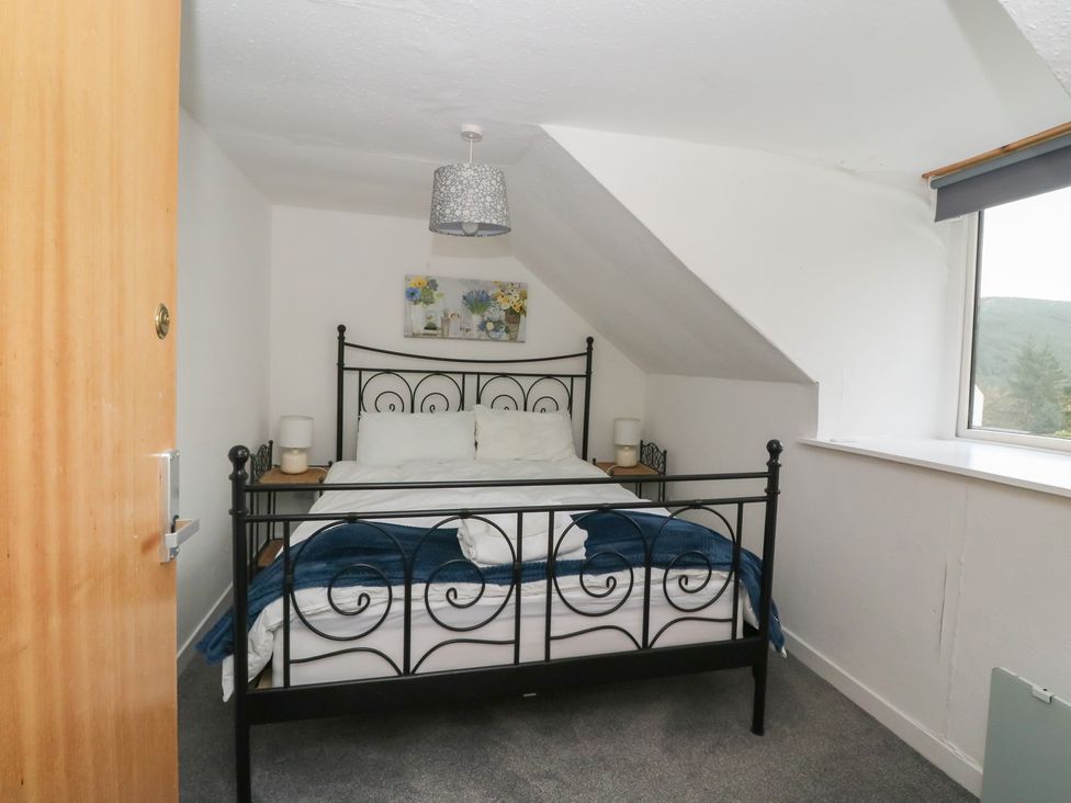 A bedroom with a bed and window at Holly Cottage near Killean Farmhouse Cottages