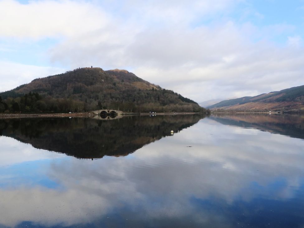 A lake with mountains and reflections at Holly Cottage near Killean Farmhouse Cottages near Inveraray