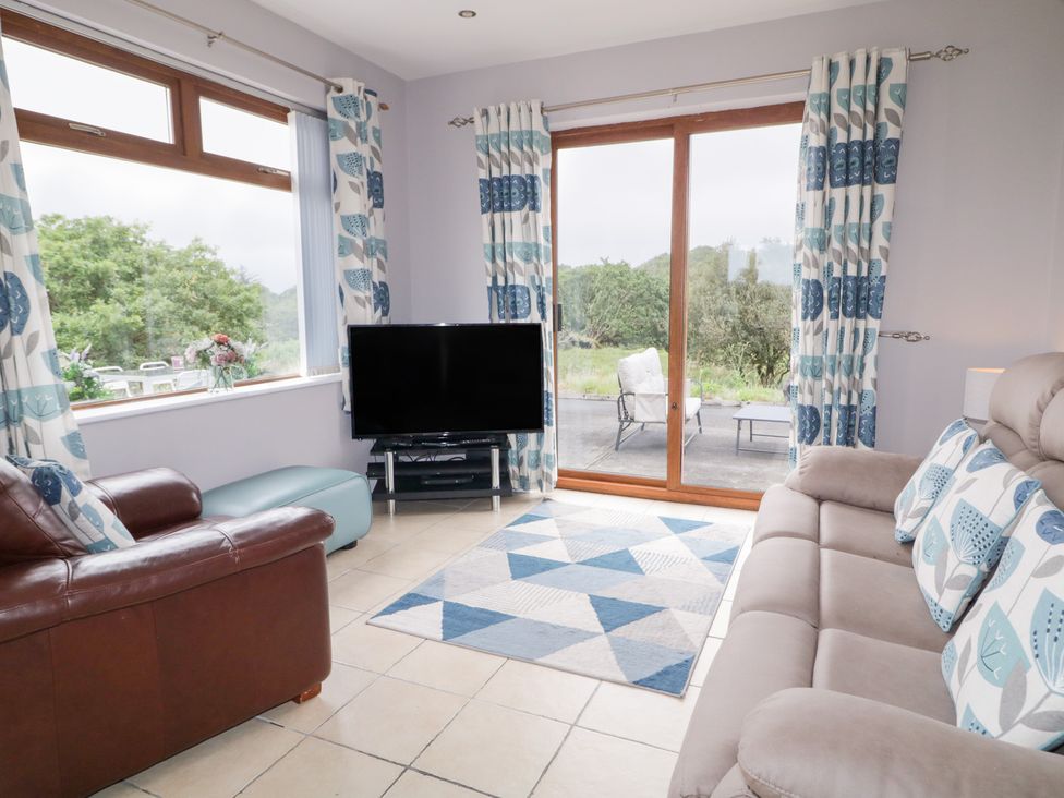 A living room with a sofa and television at Ard na Gréine in Glenties, County Donegal