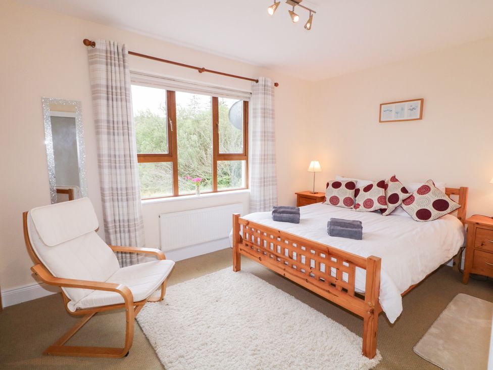 A bedroom with a bed and a chair at Ard na Gréine in Glenties, County Donegal