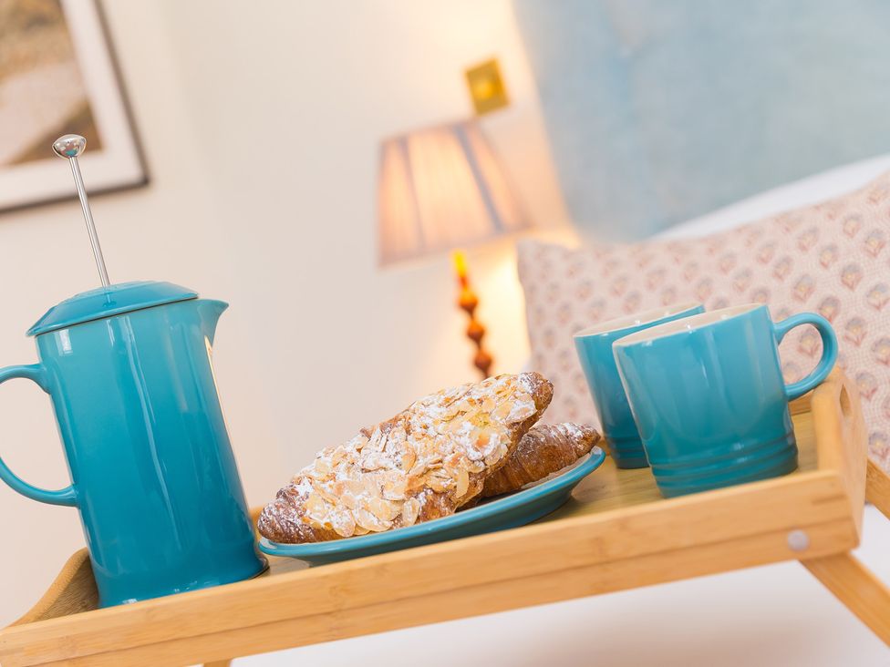 A tray with a coffee pot and croissant in a bedroom at Scilly Stack in Penzance