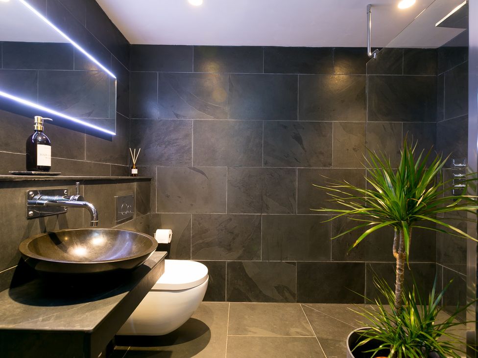 A bathroom with a toilet, vanity sink, and plant at Scilly Stack in Penzance