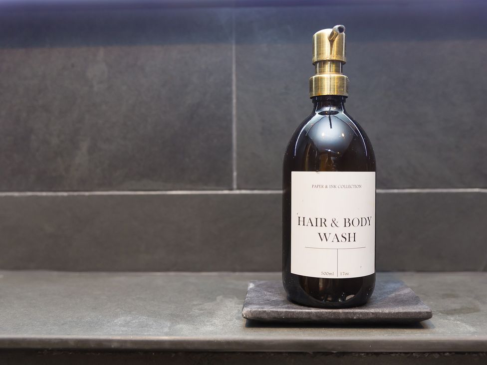 A hair and body wash bottle on a slate tray at Scilly Stack in Penzance