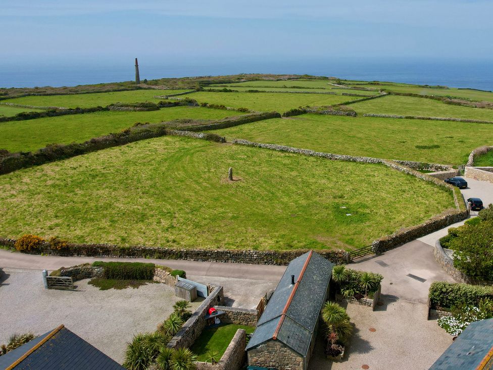 An outdoor view with grassy fields and stone walls at Scilly Stack in Penzance
