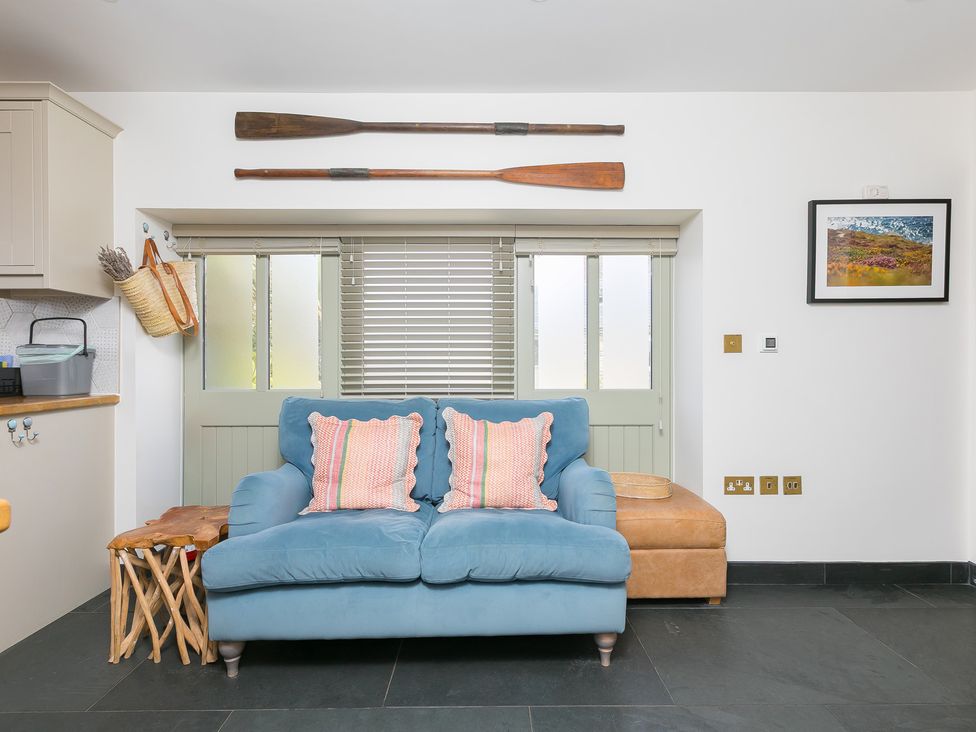 A living room with a sofa and cushions at Scilly Stack in St Just