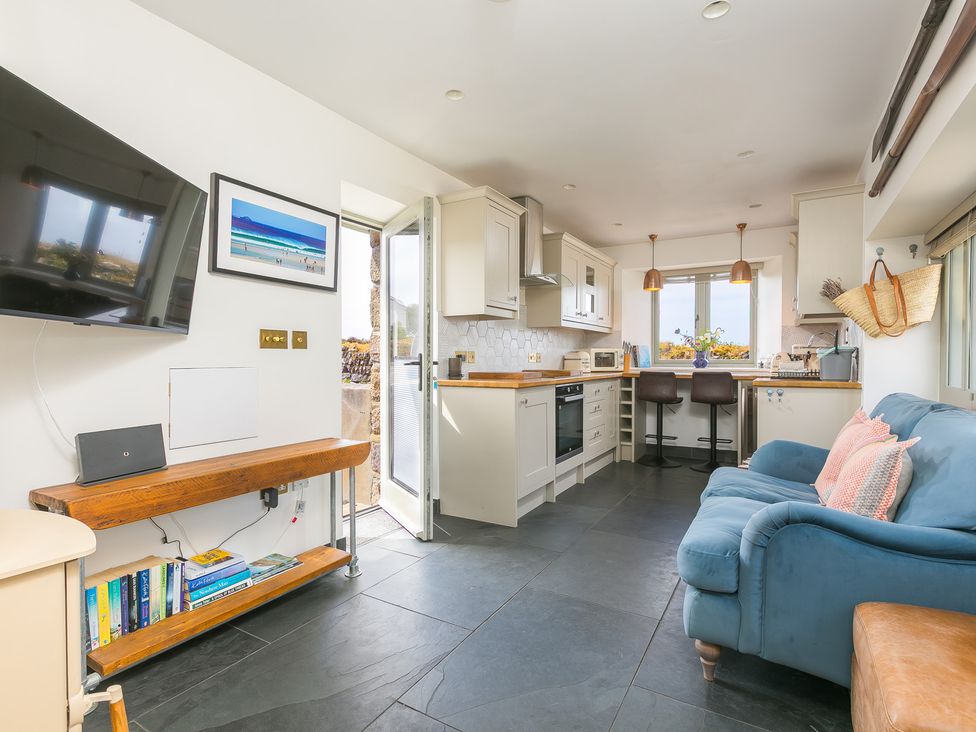 A kitchen with counter stools and appliances at Scilly Stack in St Just