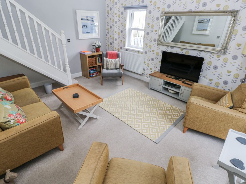 A living room with a sofa and television at Crown Cottage in Penally