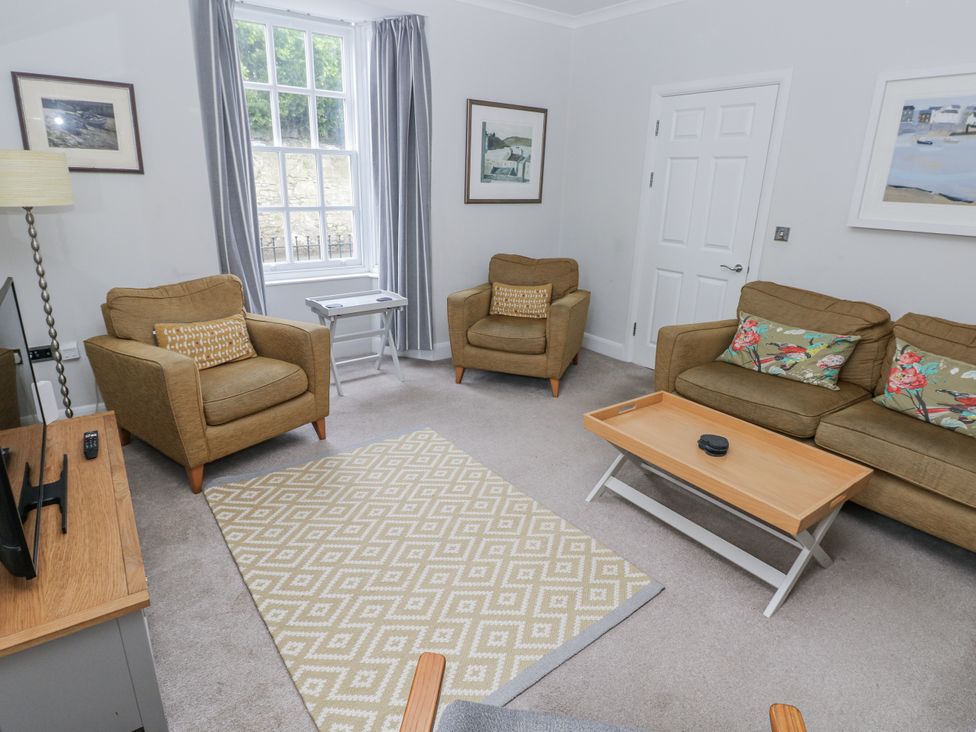 A living room with a sofa and armchairs at Crown Cottage in Penally