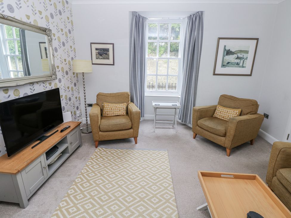A living room with a television and armchairs at Crown Cottage in Penally