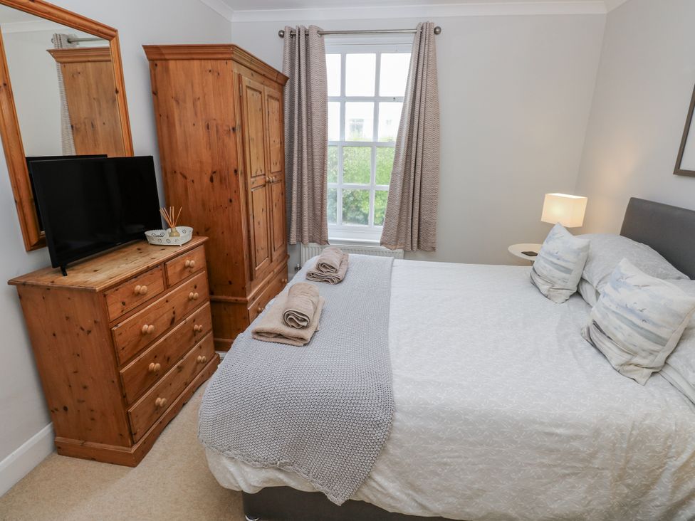A bedroom with a bed and television at Crown Cottage Penally
