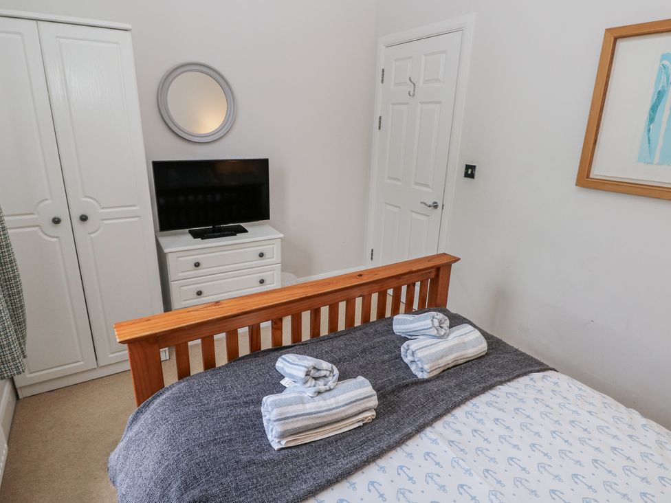A bedroom with a bed and a television at Crown Cottage in Penally