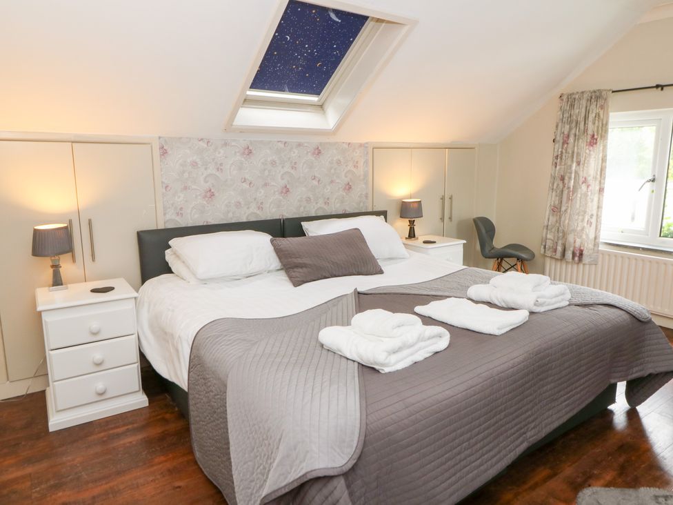 A bedroom with a double bed and nightstands at Tynewydd Fields in Cross Inn