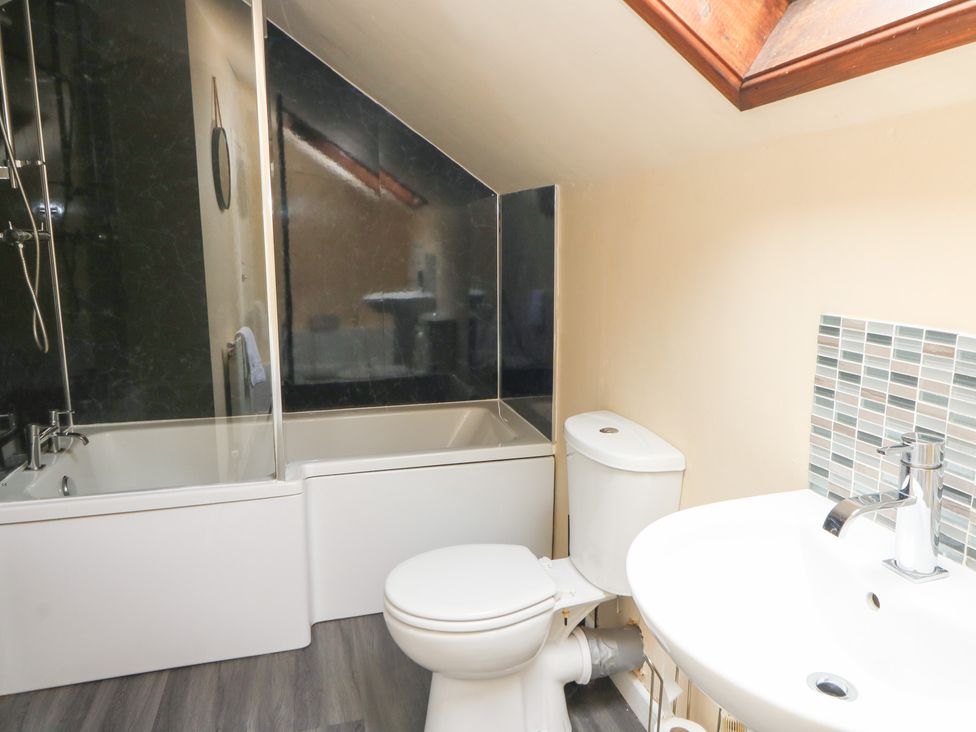 A bathroom with a bathtub, toilet and sink at Tynewydd Fields in Cross Inn