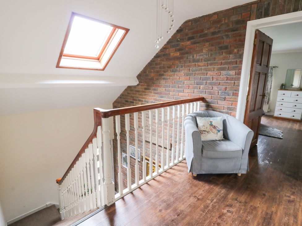 A staircase with a skylight and a chair in the hallway at Tynewydd Fields in Cross Inn